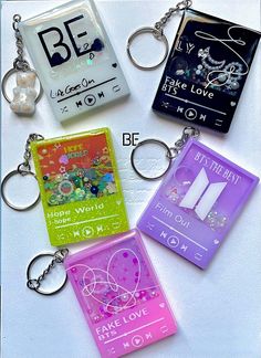 four key chains with different designs and words on them, all in the same color