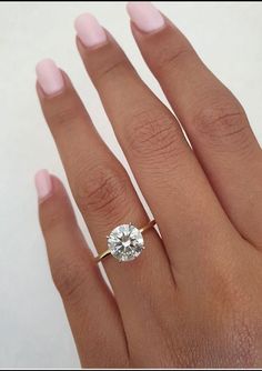 a woman's hand with a ring on it and a diamond in the middle