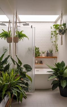 a bathroom with plants hanging from the ceiling and a bathtub in the corner next to it