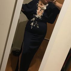 a woman taking a selfie in a mirror wearing a dress with flowers on it