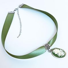 Product Info Product Care Shipping Express your one-of-a-kind style with this handmade green ribbon flower cameo necklace. Offering the perfect balance of timeless elegance and modern style, the luscious satiny green ribbon complements the cream colour flower cameo set in an aged silver setting. Make a statement with this adjustable choker necklace, complete with an extension chain and lobster closure. Could you be its next owner? handmade green ribbon flower cameo necklace 3/4” wide green ribbo Cameo Choker, Victorian Gothic Jewelry, Victorian Accessories, Handmade Chokers, Ribbon Flower, Ribbon Necklace, Cream Colour, Victorian Rings, Cameo Necklace