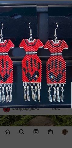 three pairs of red beaded earrings hanging from hooks