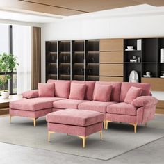 a living room with a pink sectional couch and matching footstool in front of a bookcase