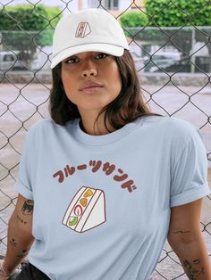 "Hand-drawn Fruit Sandwich illustration and the Japanese word \"Fruit Sandwich\" are printed on the t-shirt.  Perfect addition to your everyday outfits.   Cute to wear with matching design hat: https://www.etsy.com/listing/1383816540/fruit-sandwich-embroidered-dad-hat-fruit?click_key=c3c61617d23471b117340458a359d4d3998914ad%3A1383816540&click_sum=473181f3&ref=shop_home_active_14&frs=1 ♡Product Details♡ * 100% combed and ring-spun cotton * Athletic Heather - 90% combed and ring-spun cotton, 10% polyester * Heather Peach -  52% combed and ring-spun cotton, 48% polyester * Fabric weight: 4.2 oz/yd² (142 g/m²) * Pre-shrunk fabric * Side-seamed construction * Shoulder-to-shoulder taping ♡Sizes♡ Unisex sizes. Classic fit. Go up one or two sizes if you want an oversize. ♡Care Instructions♡ Machin Kawaii T-shirt With Funny Print And Crew Neck, Kawaii Funny Print Crew Neck T-shirt, Kawaii Crew Neck T-shirt With Relaxed Fit, Kawaii Graphic Print T-shirt With Relaxed Fit, Kawaii Crew Neck Pre-shrunk Top, Kawaii Pre-shrunk Short Sleeve T-shirt, Kawaii Short Sleeve Pre-shrunk T-shirt, Kawaii Crew Neck Pre-shrunk T-shirt, Sandwich Illustration