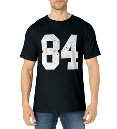 PRICES MAY VARY. Is 84 your favorite number? Win with this Great Sports Winning T-shirt for Kids Boys Girls Mom Dad Men Women Fans Football Basketball Baseball Ice Hockey or any other team sport. Wear it proudly to a game or to a 84 year old Birthday Novelty Jersey Costume Choose Perfect Gift for all day Sports Lovers Large #84 Bold Numbers Awesome Vector Design Christmas Halloween Sports Party Cool School College University Coaches Students Players 84 Coach Pick Commish Classic Subtle Distresse White Sports T-shirt With Number Print, Casual Sports T-shirt With Number Print, Black Tops With Number Print For Football Season, Team-colored Short Sleeve T-shirt With Number Print, Sporty Jersey Tops With Number Print, Sports Fan T-shirt With Number Print And Crew Neck, Black T-shirt With Number Print For Team Spirit, Sports Event Jersey Top With Number Print, Sports Jersey Top With Number Print