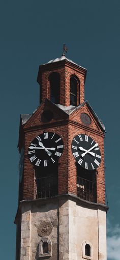 a clock tower with two clocks on each of it's sides and the sky in the background