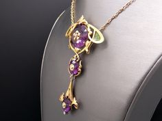 Jewelry Type: Plique A Jour Necklace ( Excllent Condition) Metal: 14k Yellow Gold Measurements: 3 3/4 inches x 2 inches (center section) 20 inch (length of chain) Markings: None Weight: 41.7 grams Main Stone: 3 Round Amethyst Color: Purple Measurement: A) 22mm x 11mm 20cts approx B) 12mm x 7mm 3cts approx C) 12mm x 7mm 3cts approx Gem Weight: 26ct approx Accent Stones: 6 matching Round Rose Cut Diamonds Color: I Clarity: SI-1 Gem Weight: 0.06ct approx. #12383 Luxury Purple Cabochon Jewelry, Luxury Amethyst Necklace For Formal Occasions, Luxury Amethyst Jewel Necklace, Luxury Amethyst Jewel Necklaces, Luxury Amethyst Necklace With Jewels, Exquisite Amethyst Necklace For Formal Occasions, Exquisite Formal Amethyst Necklace, Luxury Purple Pendant Necklace, Collectible Yellow Gold Necklaces With Gemstone