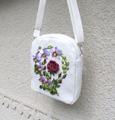 a white purse with flowers painted on it