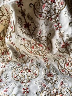 an embroidered white fabric with red and gold designs