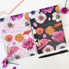 two notebooks with flowers on them next to a pen and flower potted plant