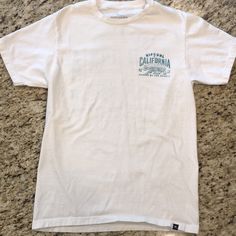 Nwot Ripcurl California Bear White T-Shirt, Size Small White Crew Neck Top With Front Print, Casual White Print Short Sleeve Shirt, White Short Sleeve Casual Tops, White Pre-shrunk Cotton T-shirt, White Crew Neck T-shirt With Front Print, White Cotton Graphic Tee, White Cotton Shirt With Graphic Print, Casual White Print Cotton Tops, White Graphic Tee With Crew Neck