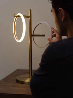 a man is looking at an illuminated object on a table with the light turned on