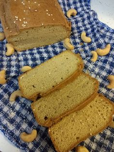 three slices of bread sitting on top of a blue and white checkered cloth next to cashews