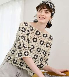 a woman standing next to a wooden table with a hat on it's head