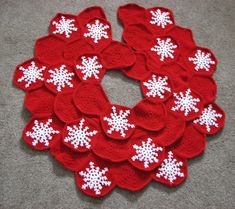 red and white crocheted snowflakes arranged in a circle on the floor