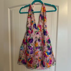 a dress hanging on a hanger in front of a white door with a blue handle