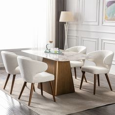 a dining room table with white chairs and a marble top