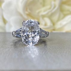 an oval cut diamond ring with baguettes on the side