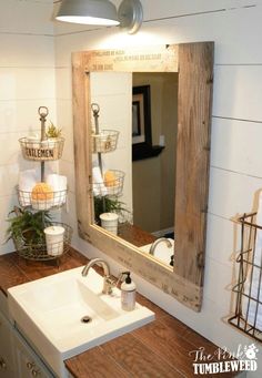 a bathroom sink sitting under a mirror next to a wooden shelf with baskets on it