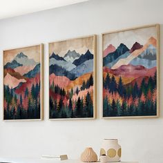 three paintings hanging on the wall above a table