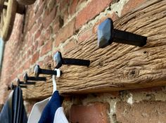 clothes hanging from hooks on a brick wall