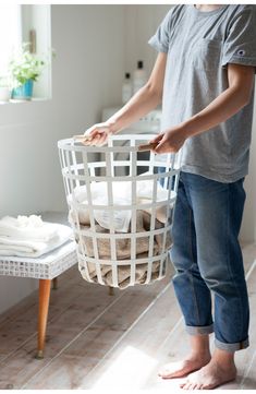 a young boy holding a laundry basket in his hands