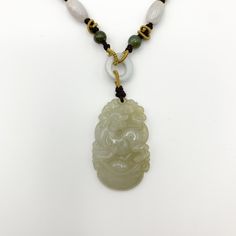 This is a high grade jadeite jade pendant necklace. It is exquisitely hand carved, so each pendant is different in some way. The pendant is completely natural jade, un-dyed and in its natural form. The pendant is carved in the form of the Chinese Zodiac - Dog. The beads above the pendant on the necklace are natural hand carved jadeite jade beads. They may not be perfectly round because they are hand carved. This gives the necklace a more rustic and natural stone like look. The years of the Dog i Handmade Jade Flower Pendant Necklace, Handmade Jade Necklace With Flower Pendant, Jade Amulet Pendant Necklace, Handmade Jade Necklaces For Good Luck, Traditional Engraved Jade Necklace, Spiritual Engraved Jade Necklace, Jade Pendant Amulet Jewelry, Jade Amulet Pendant Jewelry, Spiritual Jade Jewelry With Large Pendant