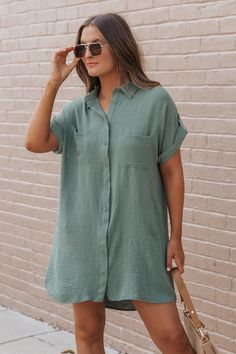 This Green Shirt Dress is a stylish and versatile piece perfect for casual occasions! Made from 100% polyester, this dress offers a comfortable fit with a smooth, lightweight feel. The button-up front and drop shoulder design add a modern touch to a classic silhouette, while the side pockets enhance functionality. Style it with flat sandals, a crossbody, and simple jewelry for a relaxed, everyday look. Casual Button-up Shirt Dress For Day Out, Solid Color Button-up Shirt Dress For Beach, Button-up Shirt Dress For Beach In Solid Color, Button-up Shirt Dress In Solid Color For Beach, Casual Collared Shirt Dress In Solid Color, Button-up Solid Color Shirt Dress For Beach, Casual Collared Solid Color Shirt Dress, Casual Solid Shirt Dress For Daywear, Relaxed Fit Button-up Dress In Solid Color