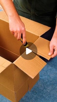 a man is opening a box with a pair of scissors