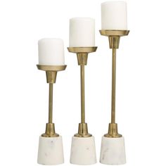 three brass and marble candlesticks with white frosted candle holders on each one