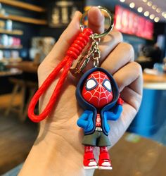 a hand holding a spider man key chain