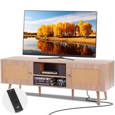 a flat screen tv sitting on top of a wooden entertainment center next to a remote control