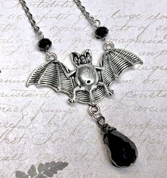 Silver bat necklace with black glass drop! Handmade.  product details On a 18 inch (35.56 cm) silver plated chain with short extender chain. Bat is silver plated. 2 inches wide (5.08 cm) Faceted black glass drop  I hope you enjoy my handmade creations and please visit the rest of my shop for items: https://www.etsy.com/shop/AnEnchantingCreature Thank you for supporting small business  VISIT MY SHOPS HERE   * http://www.etsy.com/shop/HappyCatHouse * http://www.Etsy.com/shop/AnEnchantingCreature  CONNECT  * http://www.facebook.com/EnchantingCreature * https://instagram.com/EnchantingCreature * https://www.pinterest.com/EnchantingCreature * @EnchantingCreature  NEW TO ETSY?  A great tutorial to answer all of your questions about purchasing can be found here: http://www.etsy.com/help_guide_che Gothic Pendant Necklace For Halloween, Halloween Gothic Pendant Jewelry, Halloween Gothic Pendant Necklace, Gothic Halloween Necklace With Lobster Clasp, Gothic Black Necklace With Lobster Clasp, Black Gothic Necklace With Lobster Clasp, Adjustable Vampire Necklace For Halloween, Black Halloween Necklace With Lobster Clasp, Black Vampire Pendant Jewelry