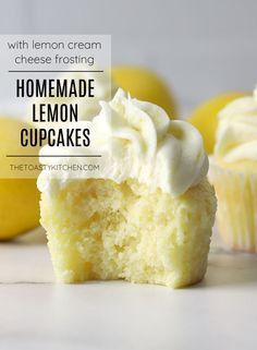 a cupcake with white frosting and lemons in the background