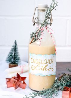 a bottle filled with liquid sitting on top of a table next to christmas decorations and presents