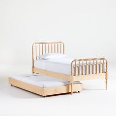 a bed with a wooden frame and white sheets on the bottom, next to a mattress