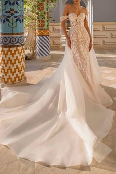 a woman in a wedding dress standing on a patio with columns and potted plants