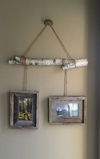 two framed pictures hanging on a wall next to a wooden pole with rope and twine