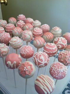 there are many pink and white cake pops on the stick