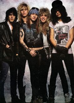 the group of young people are posing together for a photo in black leather jackets and bandannas