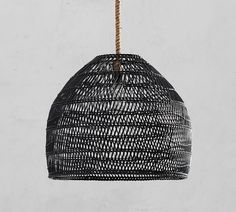 a black rattan light hanging from a rope