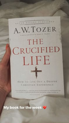 the crucified life book by awtozer is being held up in bed