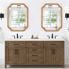 two mirrors are above the double sink vanity in this white bathroom with wood cabinetry