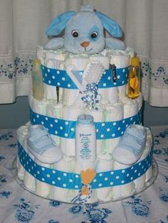 a blue and white diaper cake with a stuffed animal on top