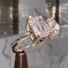 two diamond rings on top of each other in front of a marble wall and mirror