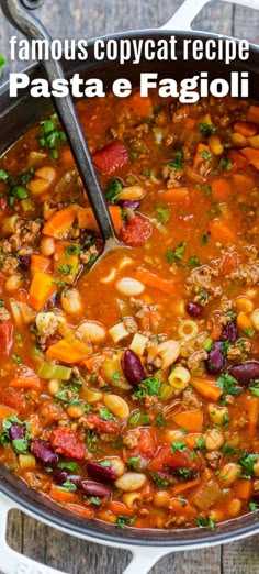 a large pot filled with soup on top of a wooden table next to a spoon