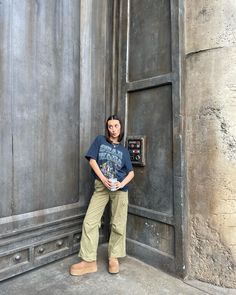 a woman standing in front of a door with her hands on her hips and looking at the camera