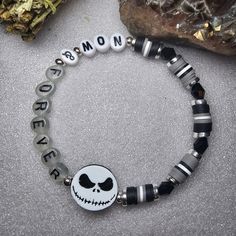 a black and white beaded bracelet with a skull on the front, says no more