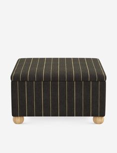 a black and white striped ottoman with wooden legs, on a gray background the foot rest is upholstered