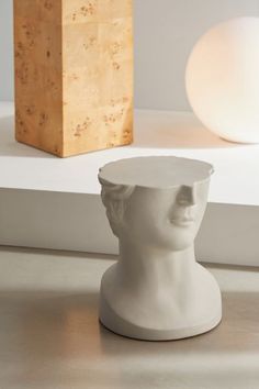 a white busturizer sitting on top of a table next to a wooden block